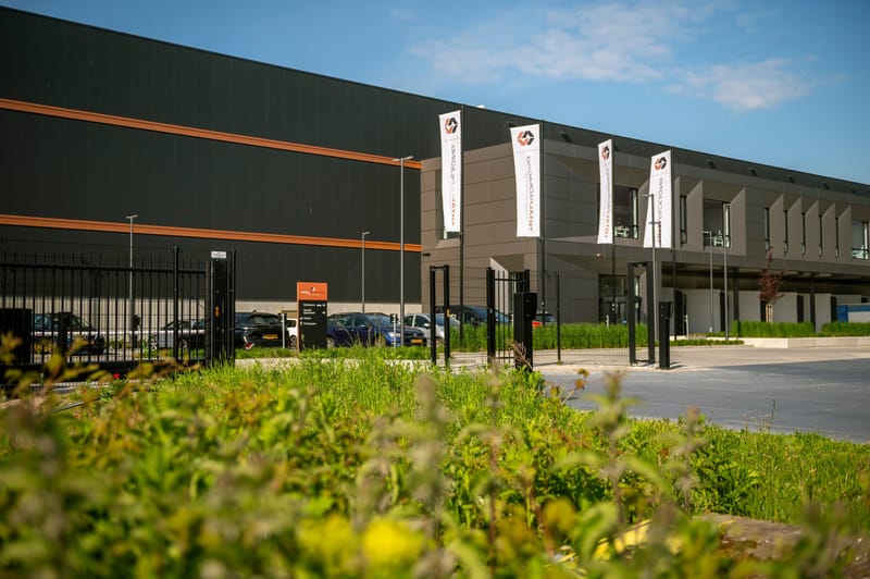 Nieuwbouw van Total Packaging in Harderwijk met hekwerk langs het terrein