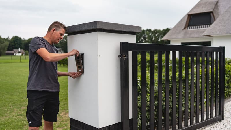 Monteur werkt aan een kolom naast een poort