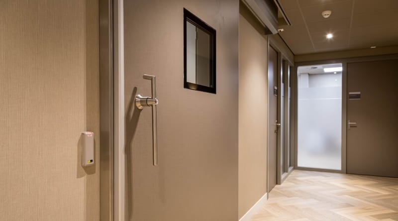 Kaartlezer naast een deur in een gang van een kliniek