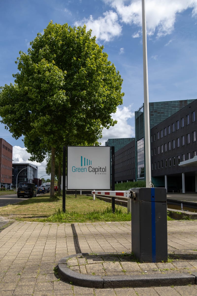 Naambord van Green Capitol bij de inrit, met een toegangszuil ernaast