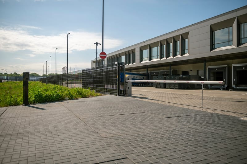 Gesloten slagboom bij de inrit van een distributiecentrum met laaddocks