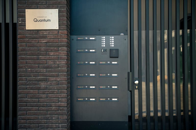 Postkastenwand met geïntegreerde intercom naast de toegangspoort van een woongebouw