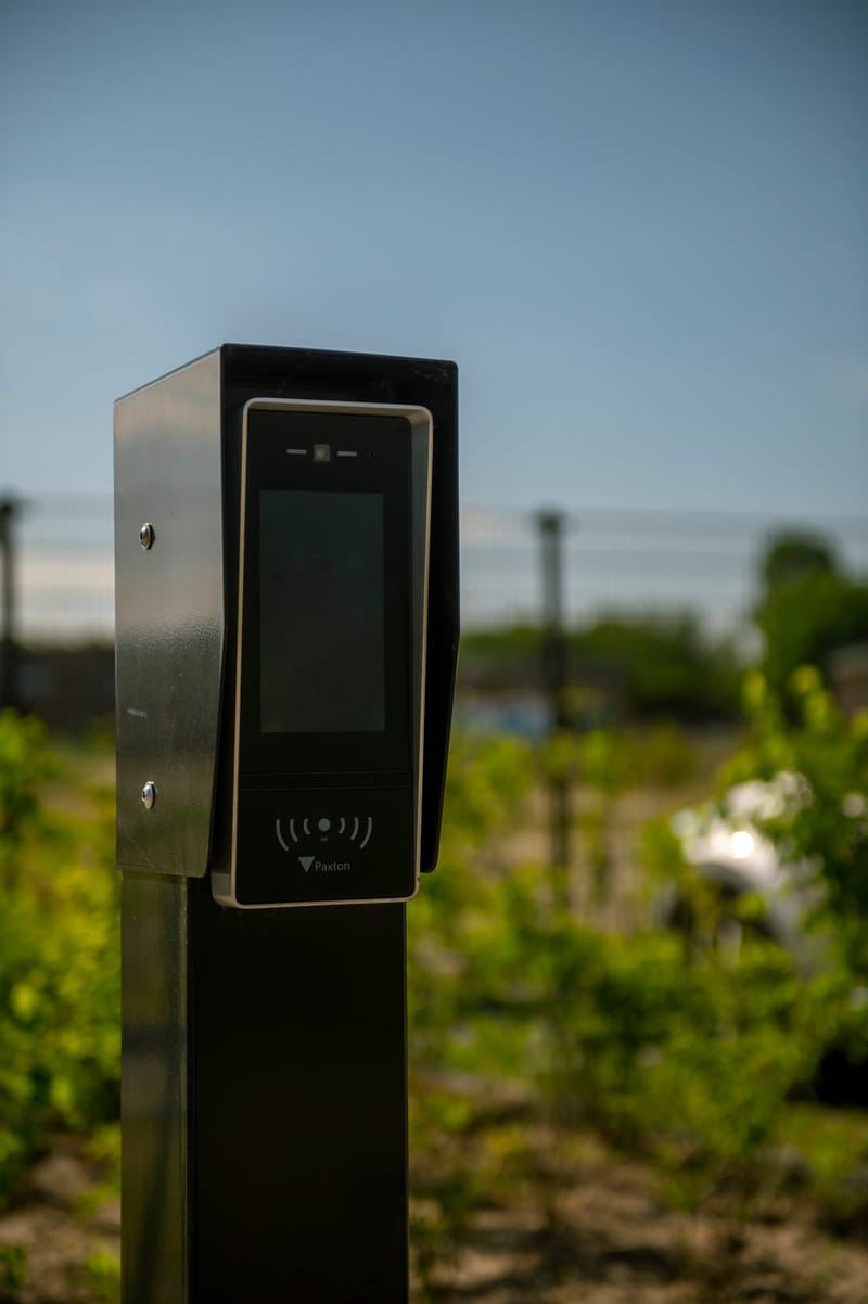 Toegangszuil met intercom en paslezer bij een bedrijfsterrein